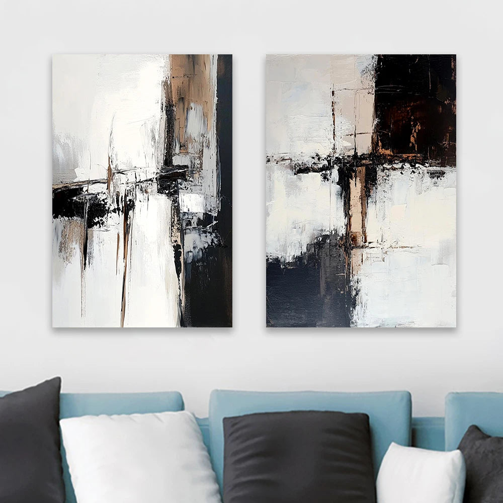 Two abstract paintings on a wall above a blue sofa with cushions.