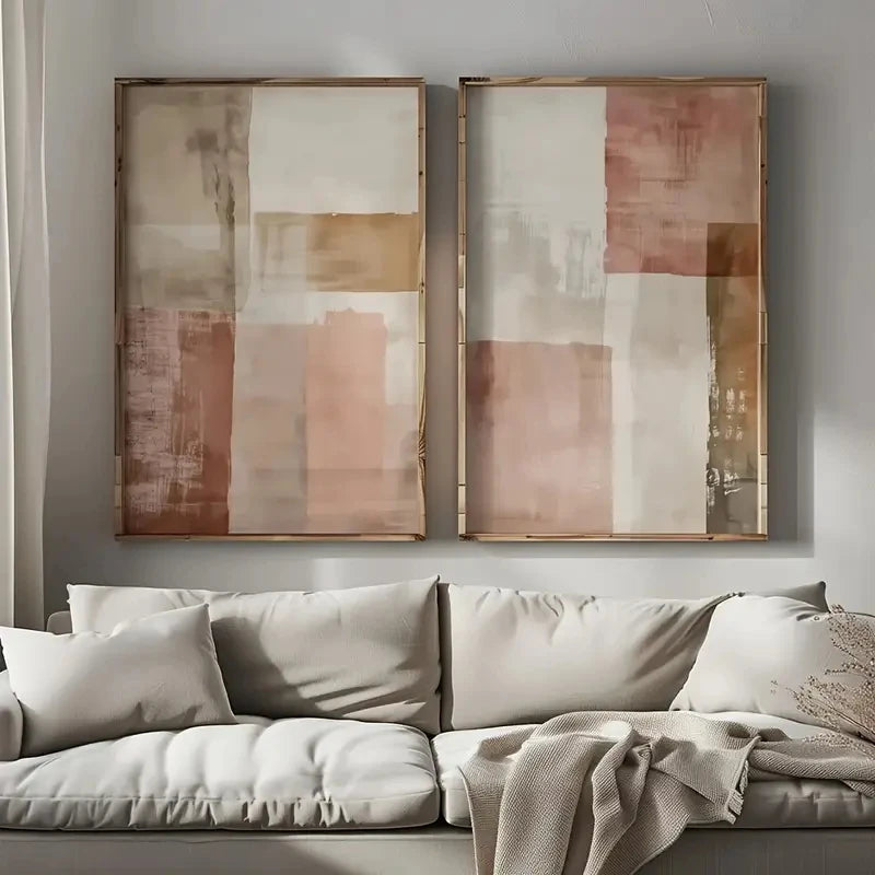 Two abstract paintings above a beige sofa in a living room.