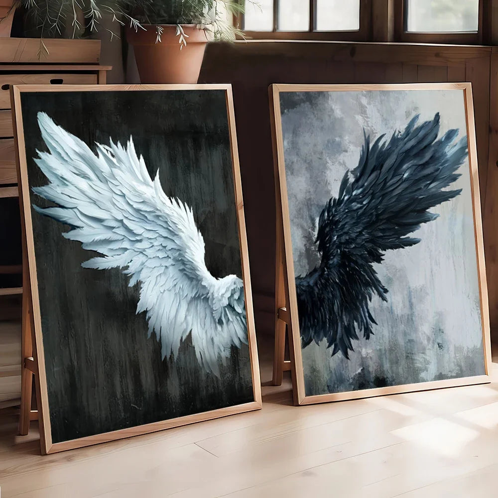 Two framed artworks of angel wings on a wooden floor.