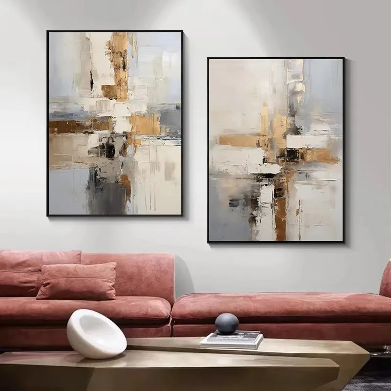 Two abstract paintings on a wall above a pink sofa with a wooden coffee table.