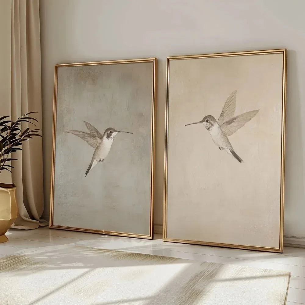 Two framed artworks of birds on a wall with a plant and curtain in the background.
