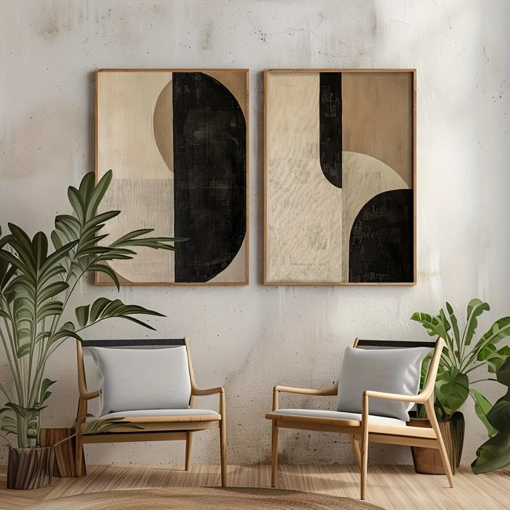 Two abstract framed artworks on a wall above two wooden chairs with white cushions, flanked by potted plants.