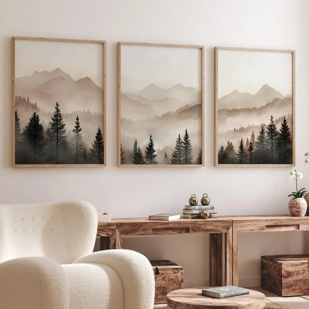 Three framed landscape prints of mountains and trees on a wall above a wooden console table.