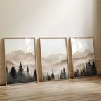 Three framed landscape paintings of mountains and trees on a wall.
