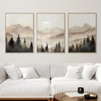 Three framed landscape paintings of mountains and trees above a white sofa in a living room.