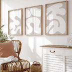Living room with wicker chair, abstract wall art, and white cabinet.