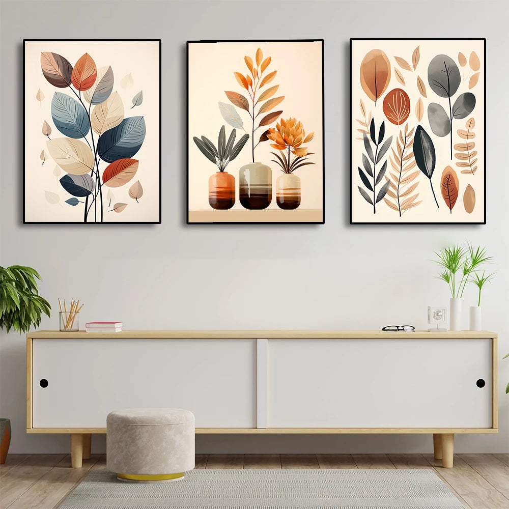 Three framed leaf art pieces above a white cabinet in a room.