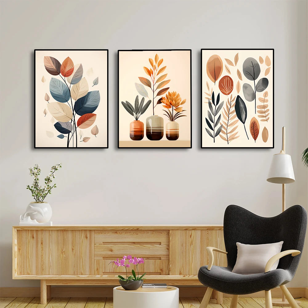Three framed leaf prints on a wall above a wooden cabinet with a modern chair and lamp.