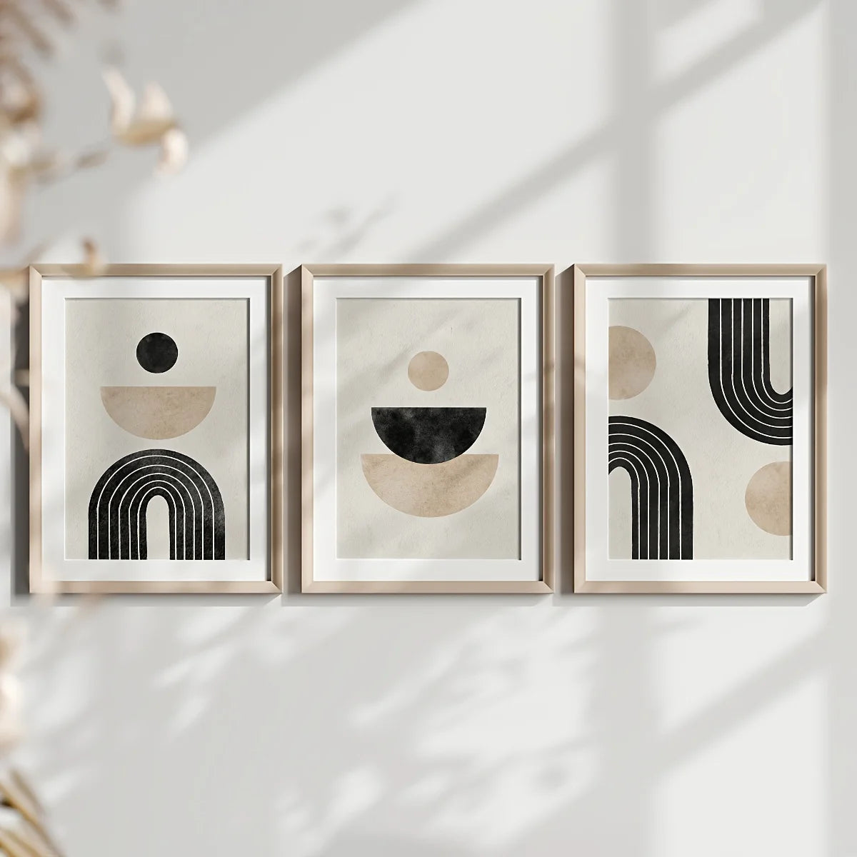 Three framed abstract art pieces on a white wall with soft shadows.