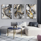 Abstract art pieces on a wall above a sofa with a coffee table.