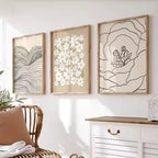 Three framed abstract artworks on a wall above a white dresser.