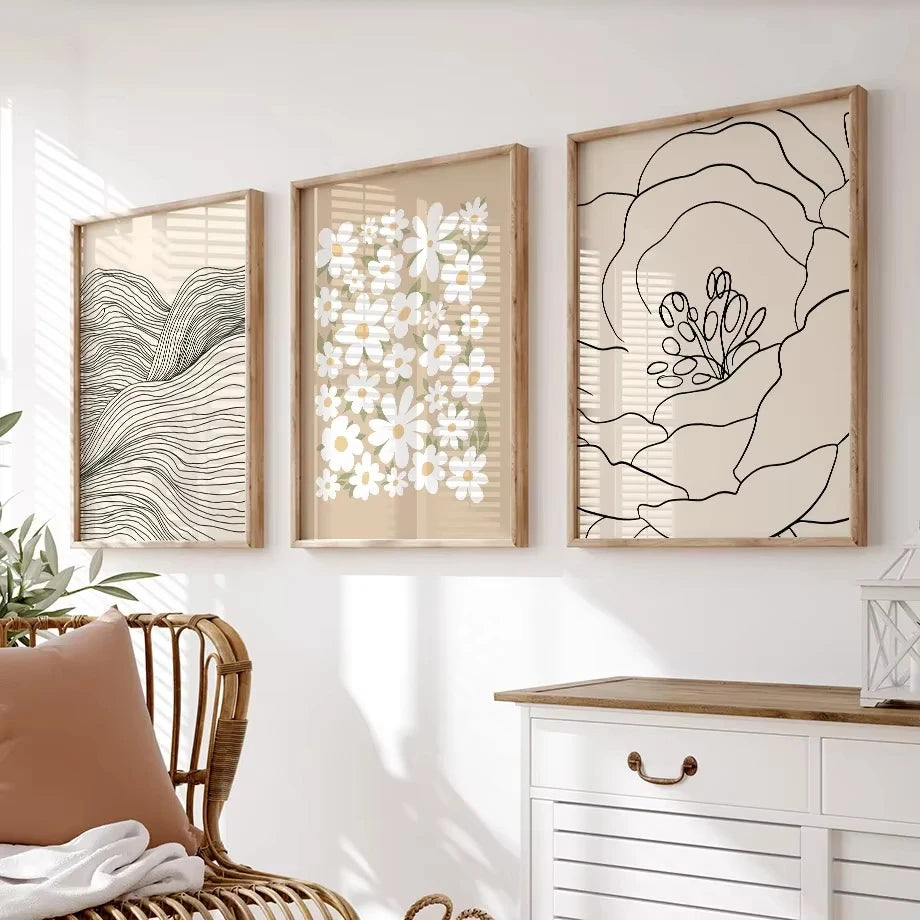 Three framed abstract artworks on a wall above a white dresser with wooden top.
