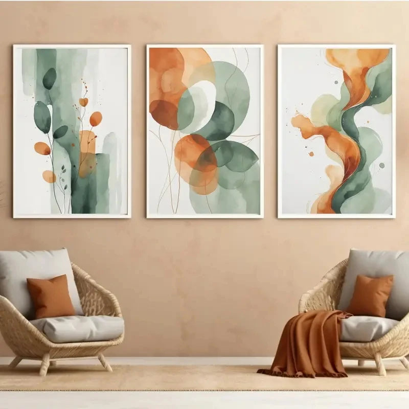 Three abstract art prints on a wall with two wicker chairs below.