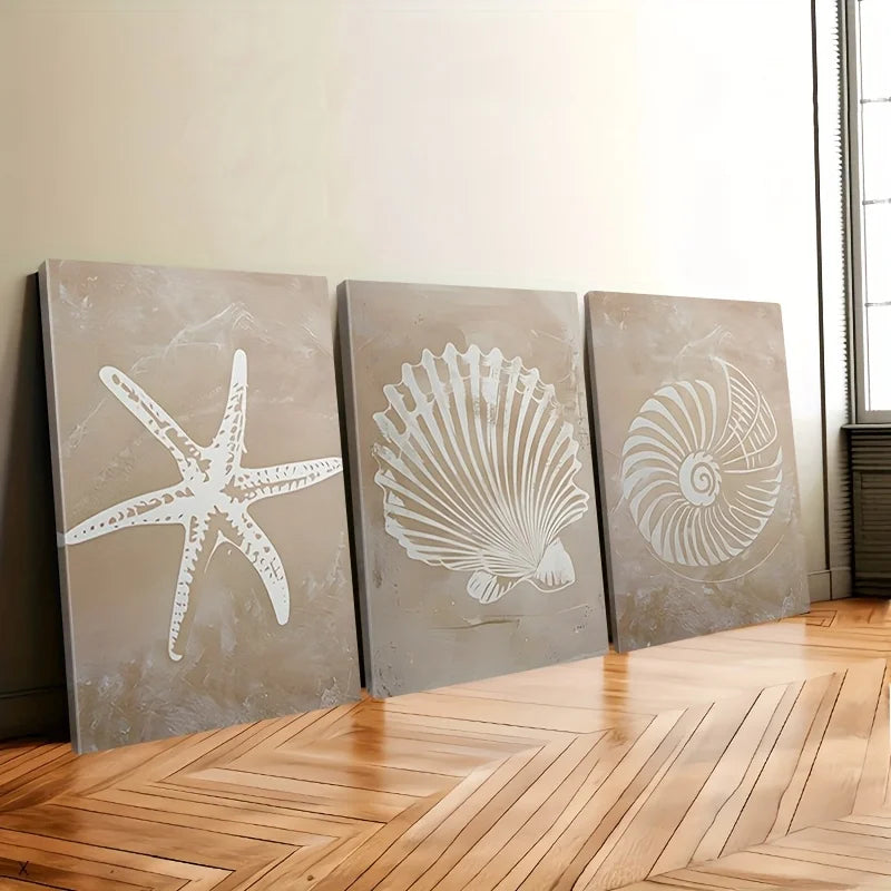 Three wall art panels with starfish, shell, and nautilus design on a wooden floor.