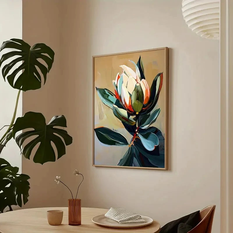Framed floral artwork on a wall with a plant and table setting below.