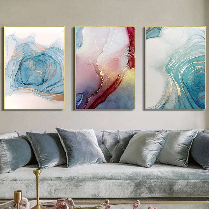 Three abstract art pieces on a wall above a gray sofa.