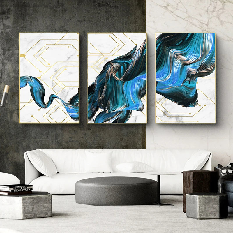 Three abstract art pieces on a wall above a white sofa in a modern living room.