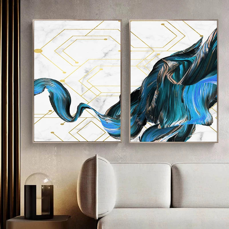 Two abstract art pieces with blue and gold designs on a wall above a sofa.