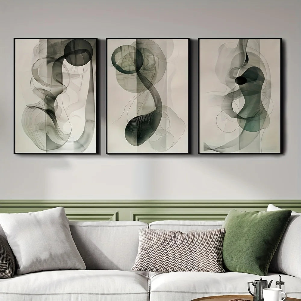 Three abstract art pieces hanging above a sofa in a living room.
