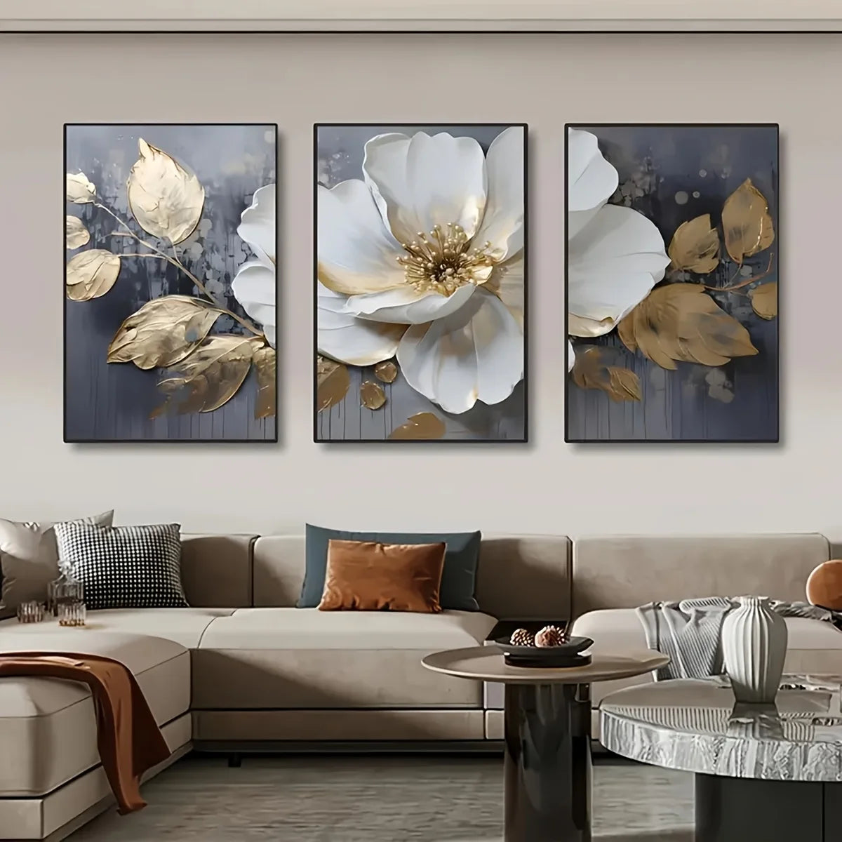 Three floral art pieces above a sofa in a living room setting.