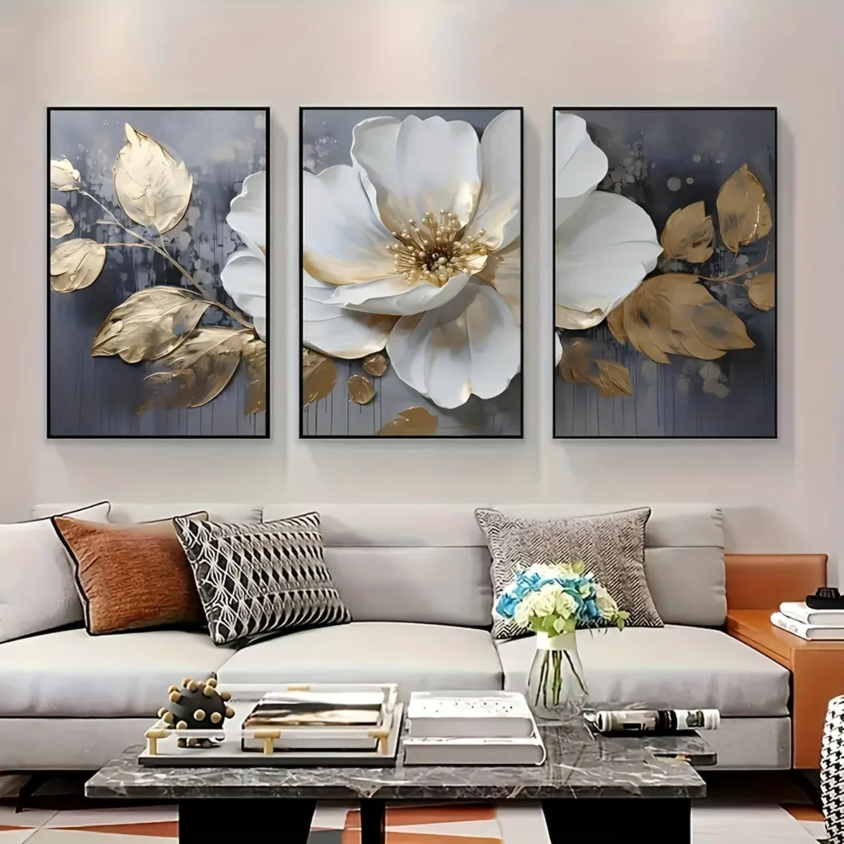 Three floral art pieces above a sofa in a living room setting.