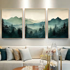Three framed landscape paintings of mountains and trees above a sofa in a living room.