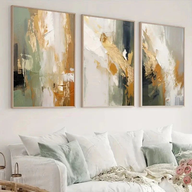 Three abstract art pieces hanging above a white sofa in a living room.
