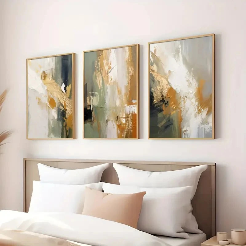 Three abstract art pieces above a bed with white bedding and pillows.