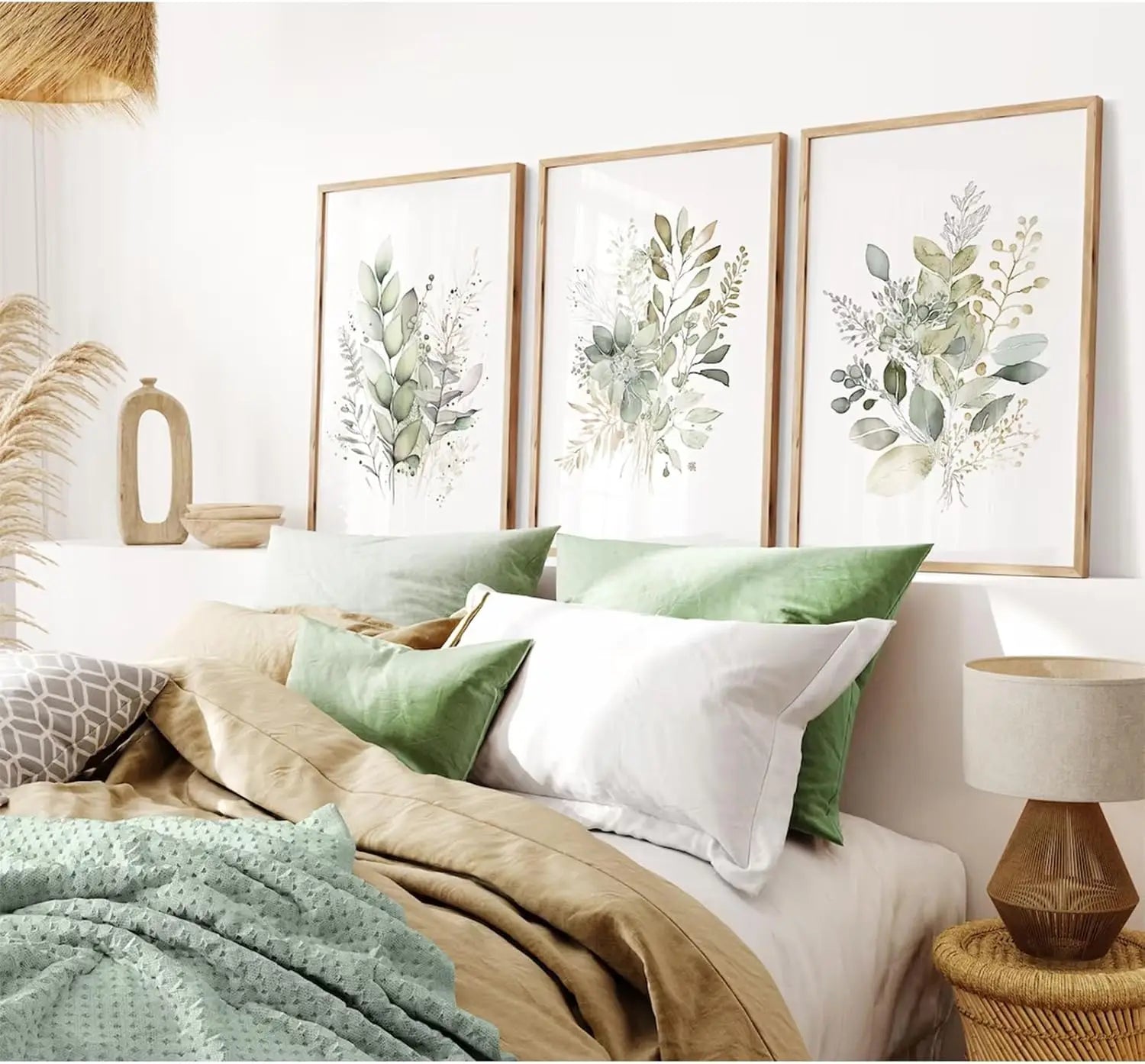 Bedroom with a bed featuring green and white pillows, framed botanical art on the wall, and a lamp.