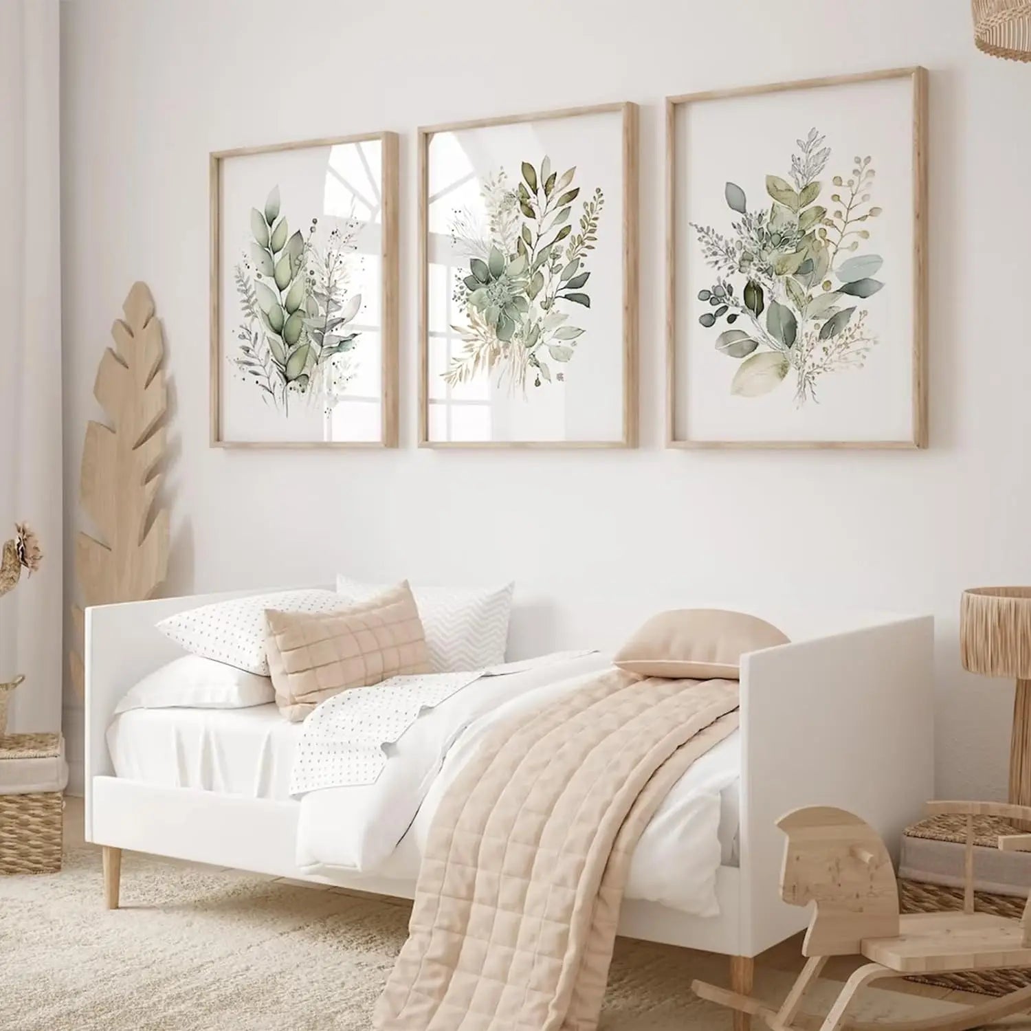 Bedroom with white bed, beige blanket, and three framed botanical prints on the wall.