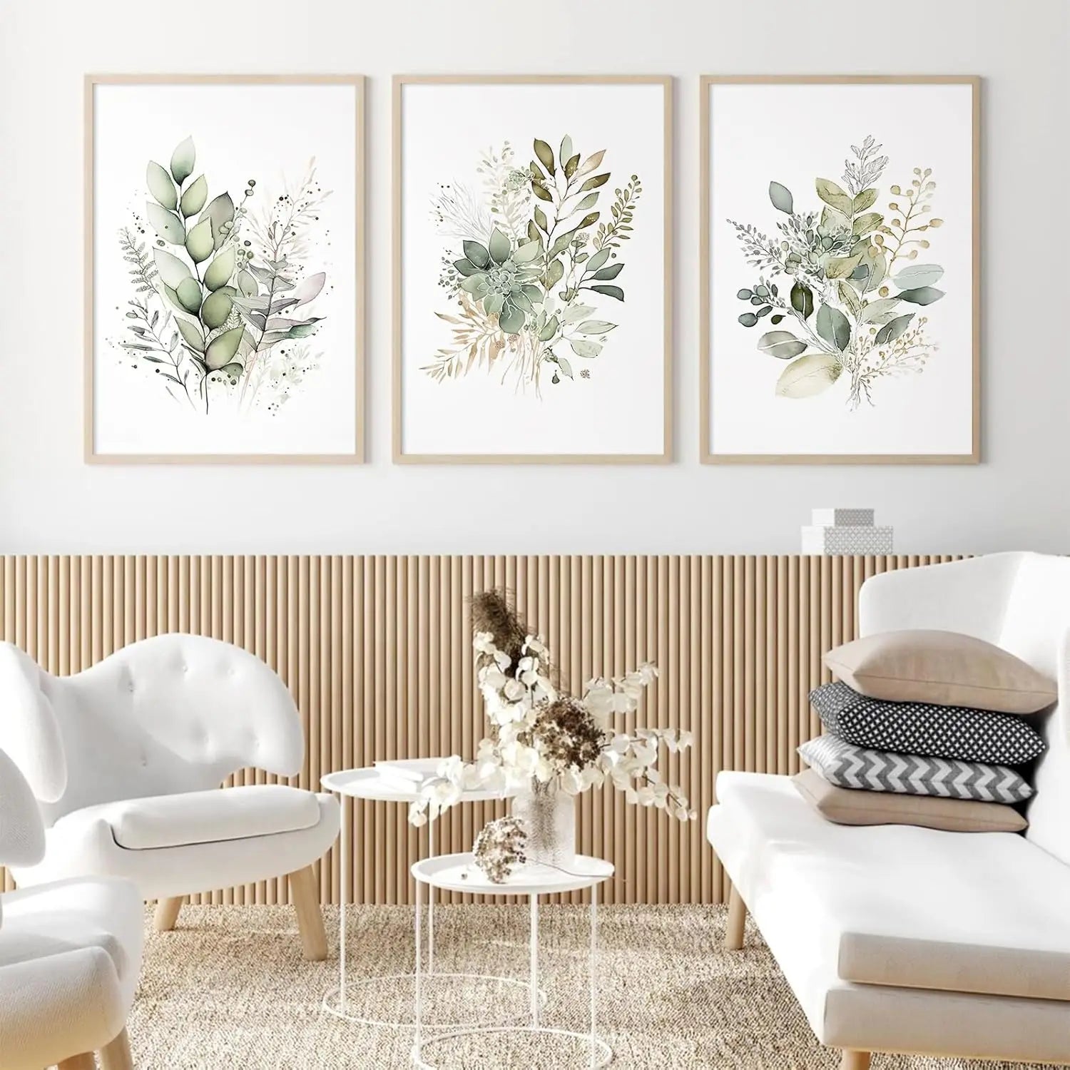 Living room with white furniture and framed botanical prints on the wall.