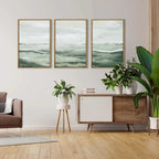 Living room with three framed artworks on the wall, a wooden sideboard, and potted plants.