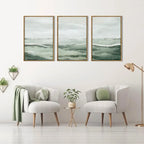 Two armchairs with decorative pillows in a room with wall art depicting green landscapes.