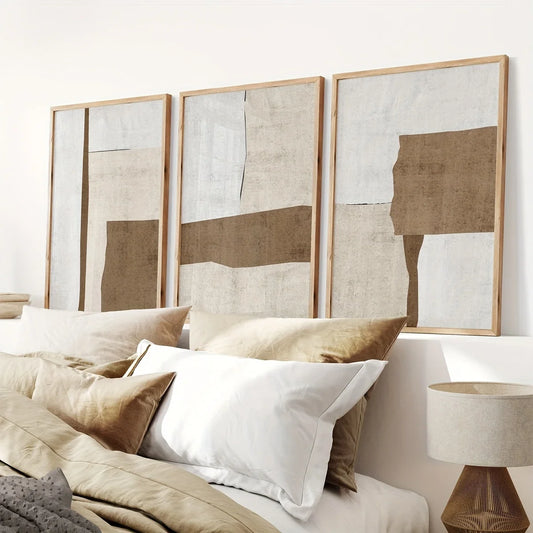 Abstract wall art in a neutral-toned room with pillows and a lamp.