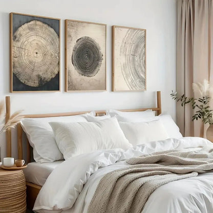 Bedroom with white bedding, wooden headboard, and wall art depicting tree rings.