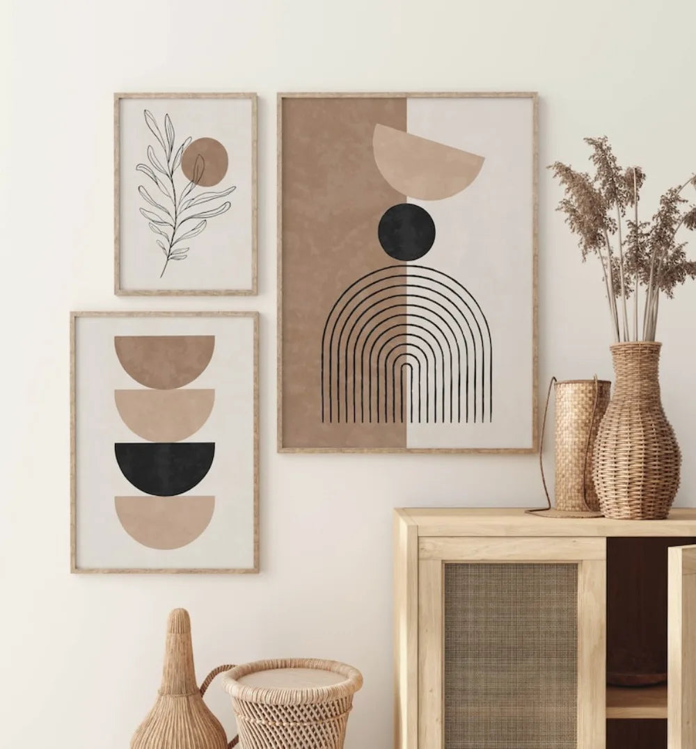 Three abstract art prints on a wall with decorative vases and a wooden shelf.