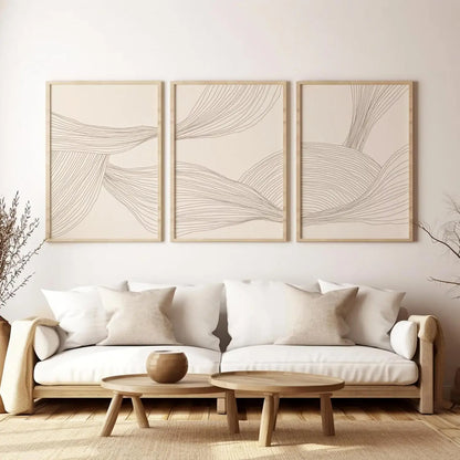 Three abstract wall art pieces above a white sofa in a living room.
