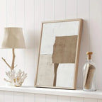 Framed abstract art piece on a shelf with a lamp and decorative bottle.