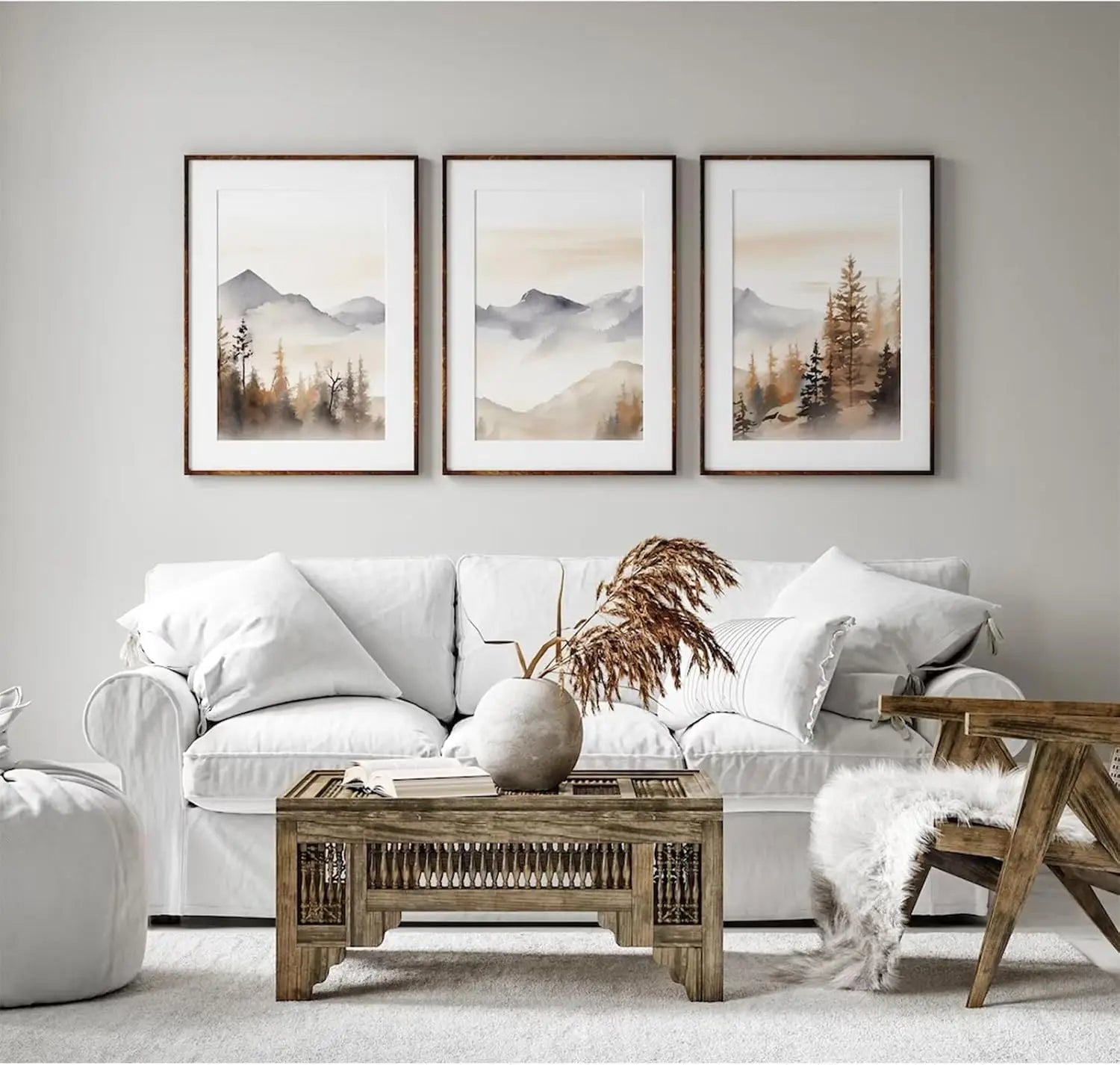 Living room with a white sofa, wooden coffee table, and framed mountain landscape art on the wall.