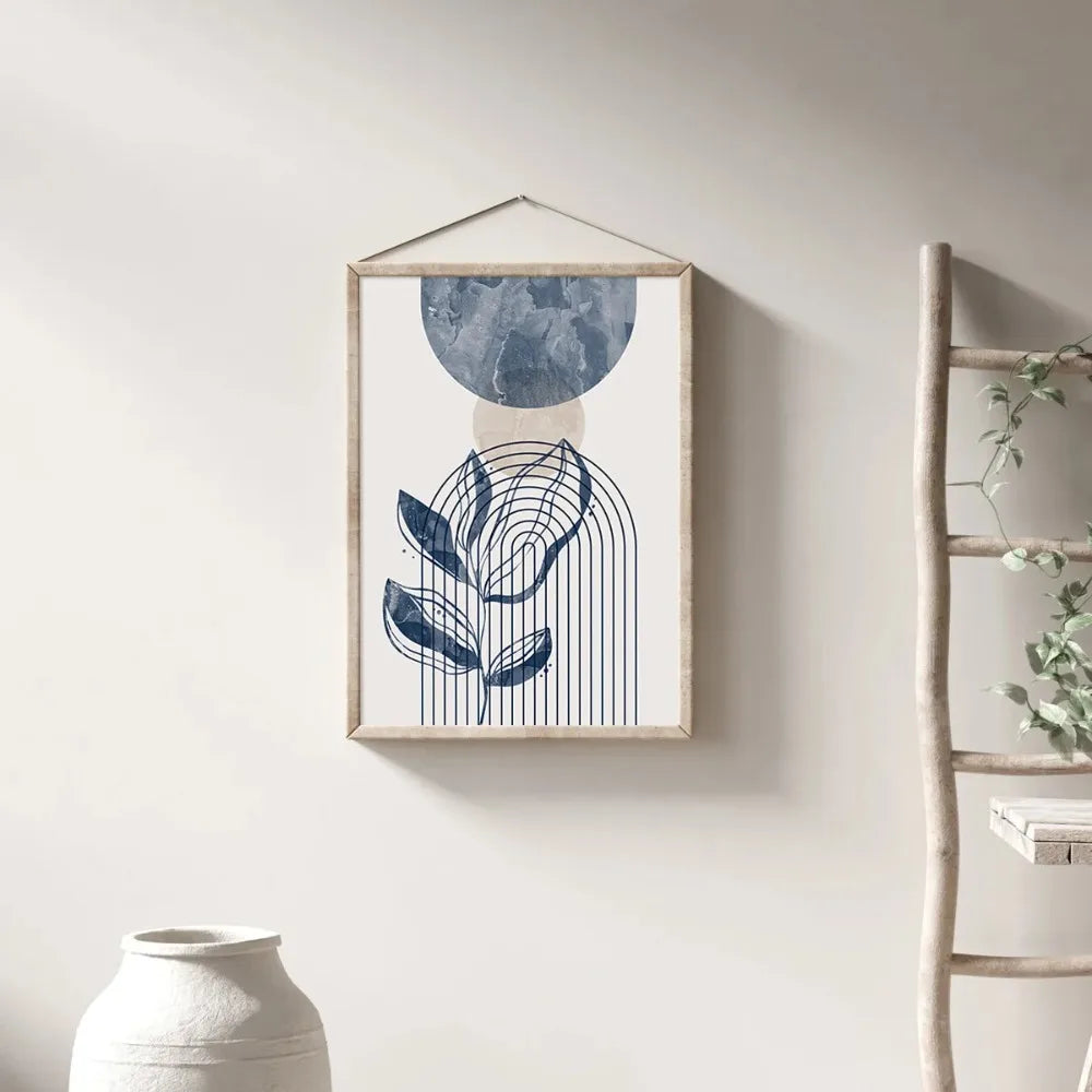 Framed abstract art print on a wall with a ladder and vase in the background
