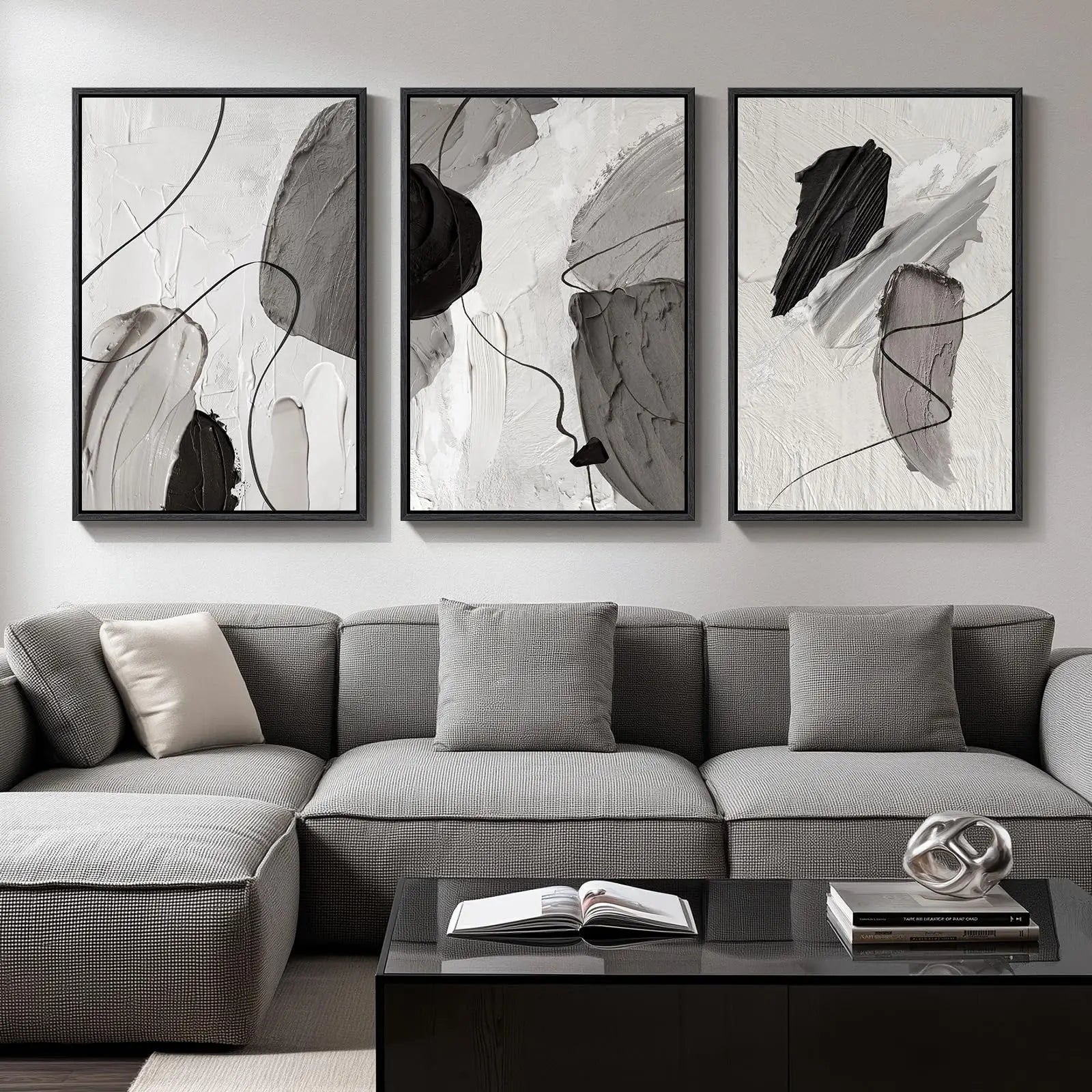 Three abstract art pieces on a wall above a gray sofa.