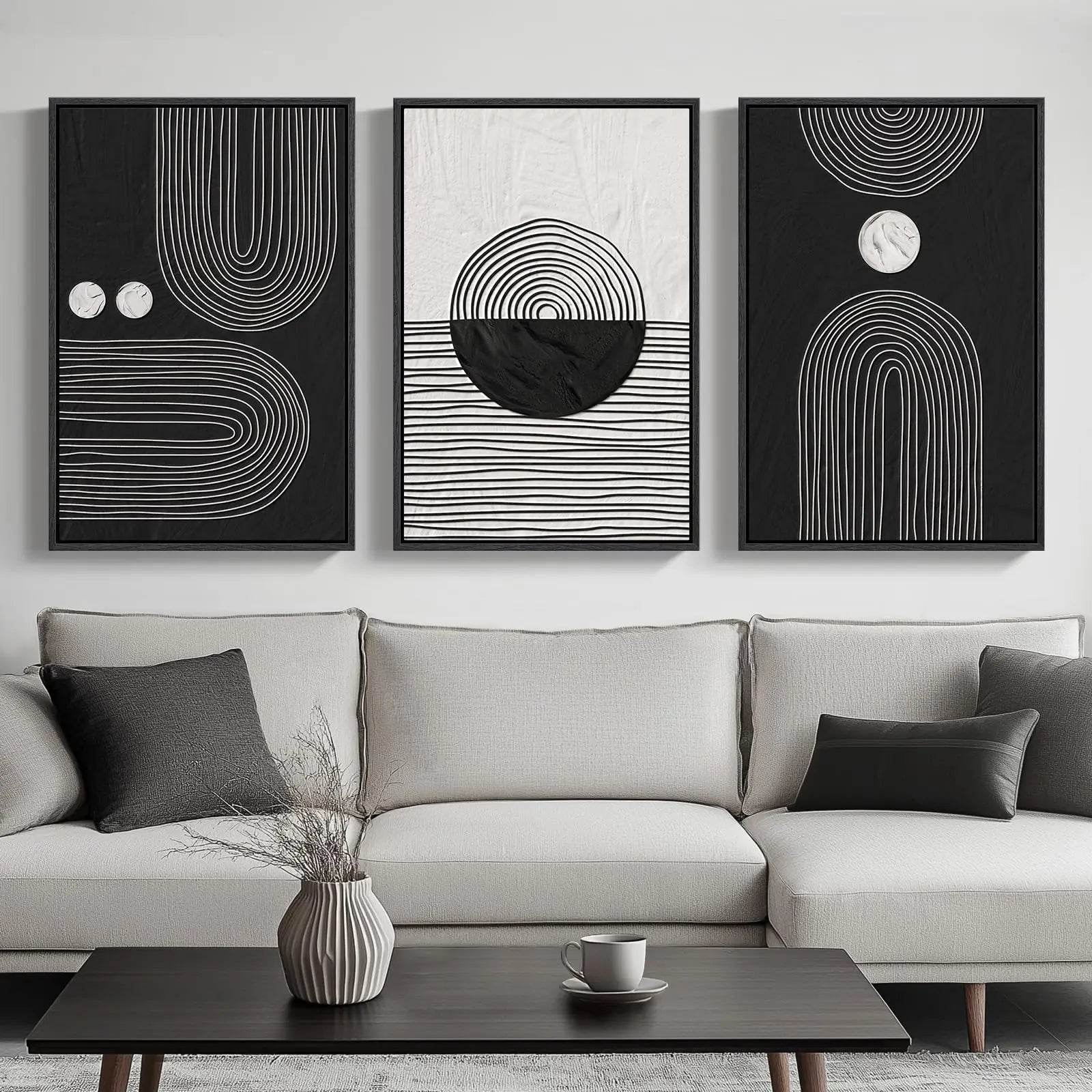 Three abstract art pieces on a wall above a sofa with decorative items on a coffee table.