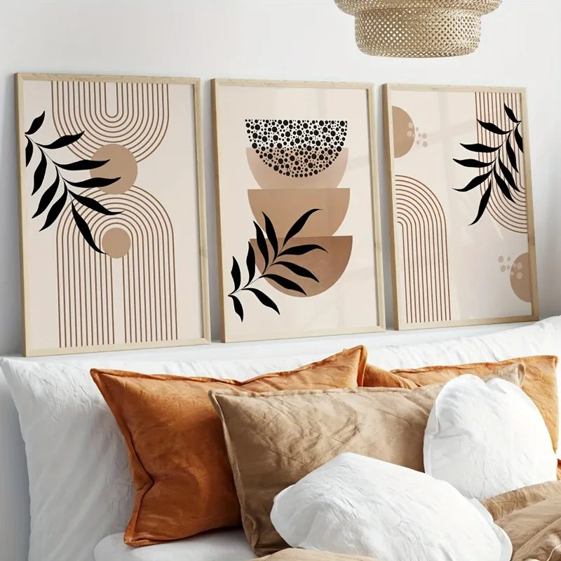 Three abstract wall art pieces above a sofa with decorative pillows.