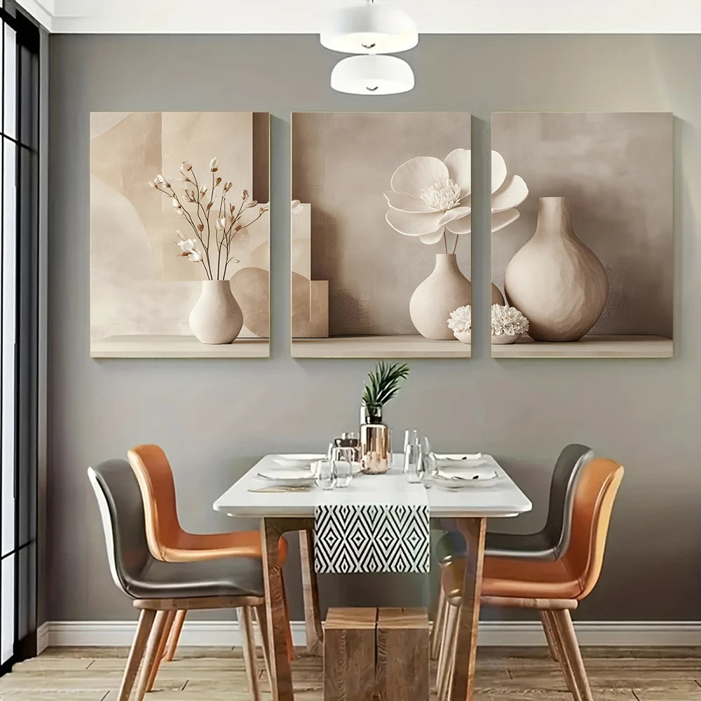 Dining room with a table set for four, three floral wall art pieces on the wall, and a vase on the table.