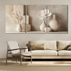 Three abstract wall art pieces above a beige sofa and chair in a living room.