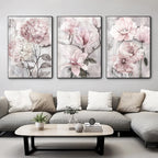 Three floral paintings above a gray sofa in a living room setting.