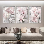 Three floral paintings above a sofa in a living room setting.