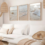 Living room with a white sofa, beach-themed wall art, and decorative items.