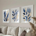 Three framed leaf artworks on a wall above a sofa.