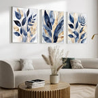Three abstract leaf paintings above a sofa in a living room.
